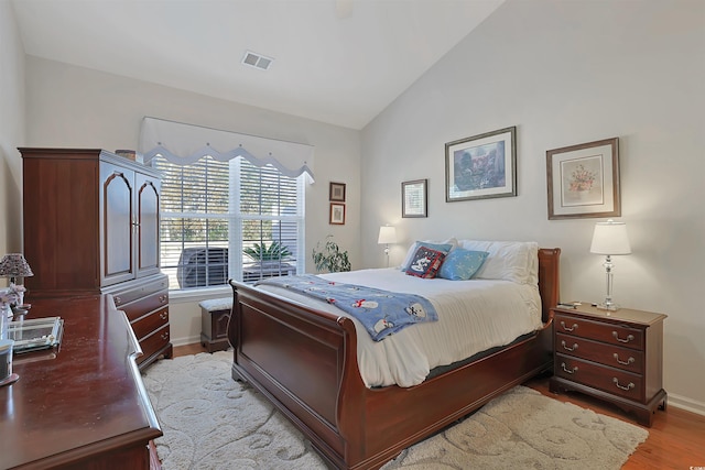 bedroom with vaulted ceiling and light hardwood / wood-style flooring