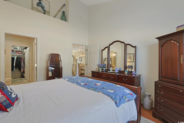 bedroom featuring a walk in closet, a high ceiling, and a closet