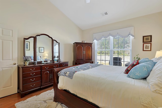 bedroom with light hardwood / wood-style floors and lofted ceiling