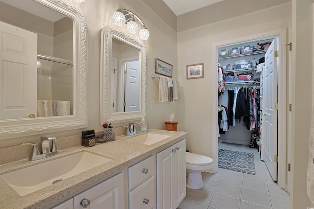 bathroom featuring tile patterned flooring, vanity, a shower with shower door, and toilet