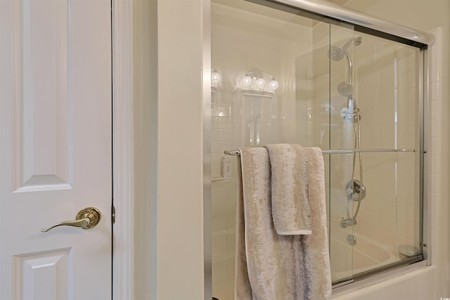 bathroom with bath / shower combo with glass door