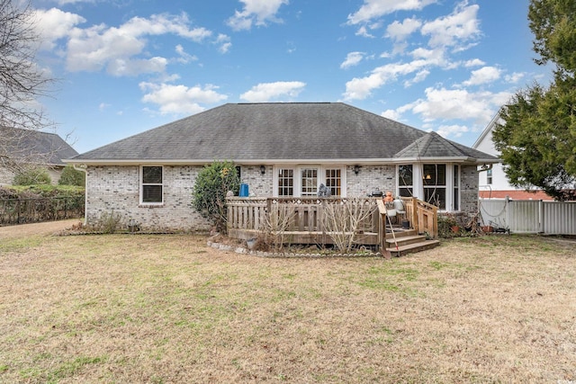 back of house featuring a lawn and a wooden deck