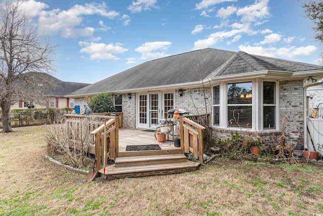 back of house with a deck and a yard