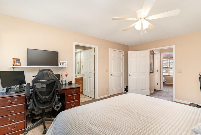 bedroom featuring light carpet, ensuite bathroom, and ceiling fan