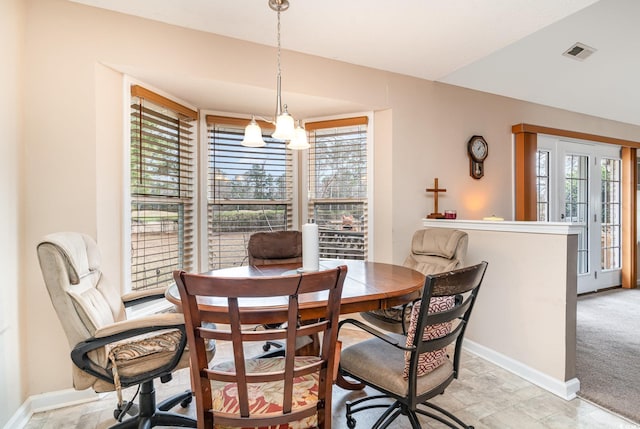 carpeted dining area featuring an inviting chandelier