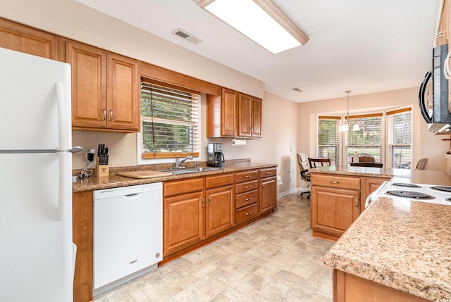 kitchen featuring white appliances, decorative light fixtures, a notable chandelier, and sink