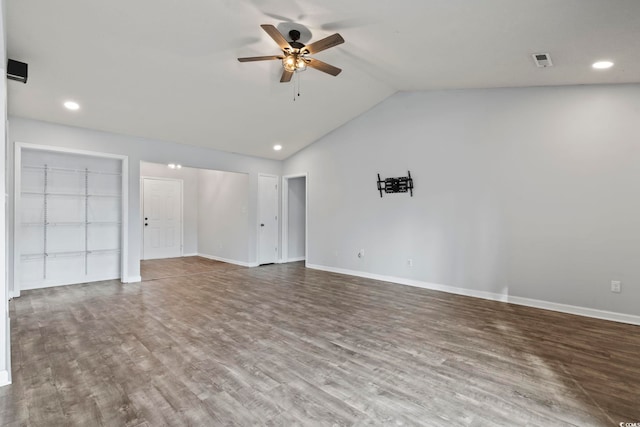 interior space with baseboards, visible vents, vaulted ceiling, and wood finished floors