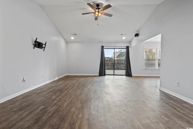 empty room with dark wood-style flooring, lofted ceiling, visible vents, a ceiling fan, and baseboards