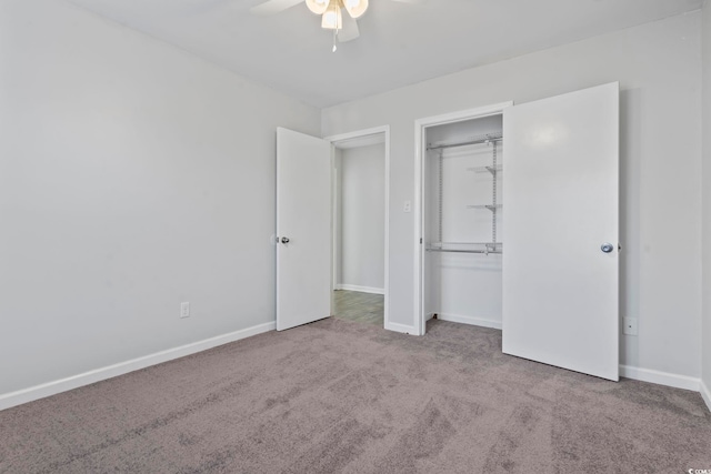 unfurnished bedroom with a closet, carpet flooring, a ceiling fan, and baseboards