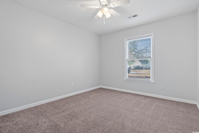 carpeted empty room with baseboards, visible vents, and ceiling fan