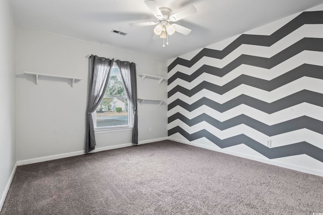 carpeted empty room featuring a ceiling fan, visible vents, and baseboards