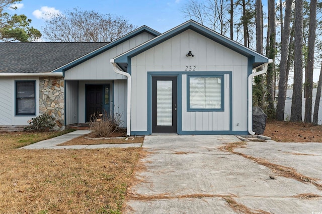 view of front of house with a shingled roof and stone siding