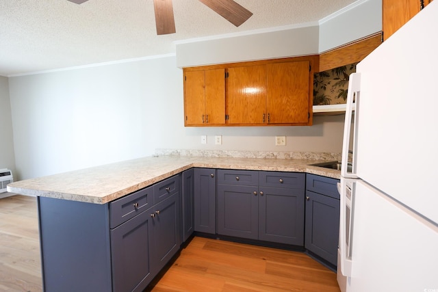 kitchen with gray cabinets, white refrigerator, kitchen peninsula, and light hardwood / wood-style flooring