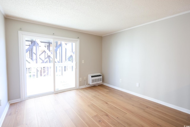 unfurnished room featuring light wood-type flooring, a textured ceiling, and a wall unit AC