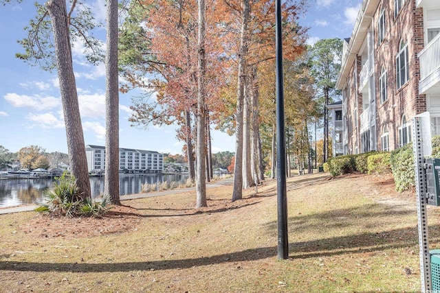 view of property's community featuring a lawn and a water view