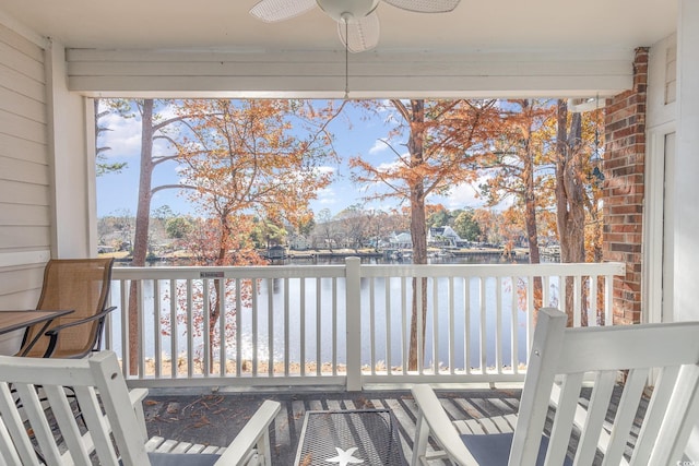 unfurnished sunroom with a water view and ceiling fan