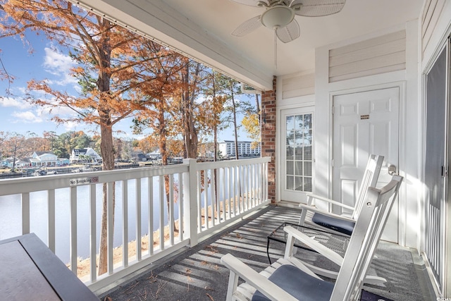 balcony featuring ceiling fan and a water view