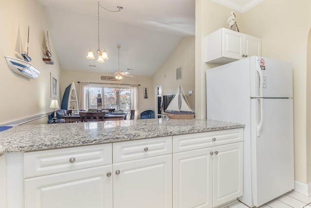 kitchen with light stone countertops, light tile patterned flooring, white refrigerator, white cabinets, and ceiling fan with notable chandelier