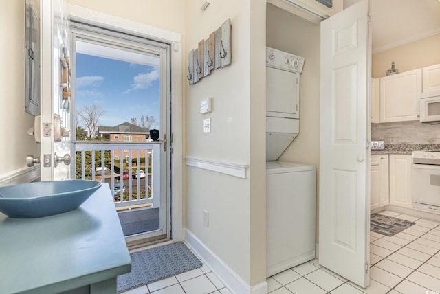 interior space with light tile patterned floors, sink, and stacked washer and clothes dryer