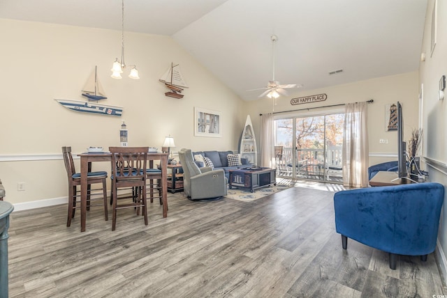 living room with vaulted ceiling, hardwood / wood-style floors, and ceiling fan with notable chandelier