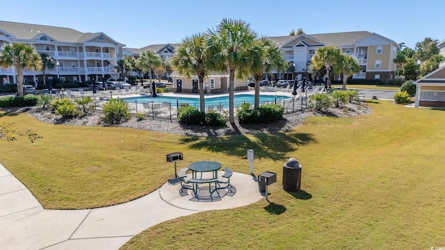 view of home's community featuring a yard, a pool, and a patio area