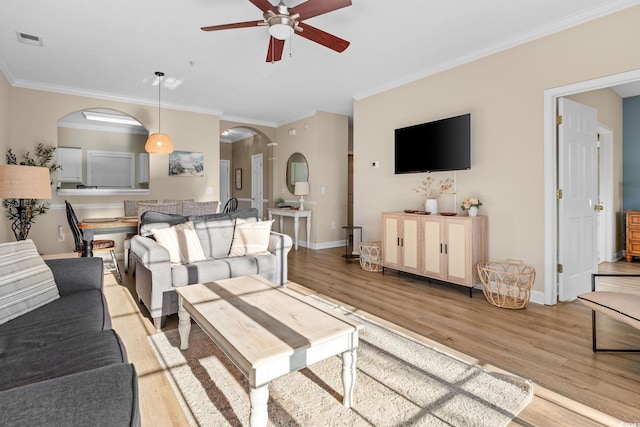 living room with light hardwood / wood-style flooring, ceiling fan, and crown molding