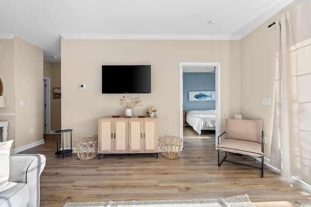 living area with light wood-type flooring and ornamental molding