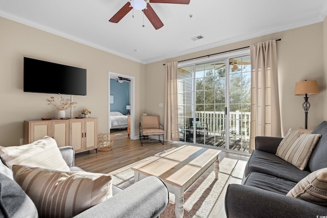 living room with ceiling fan, light hardwood / wood-style floors, and ornamental molding