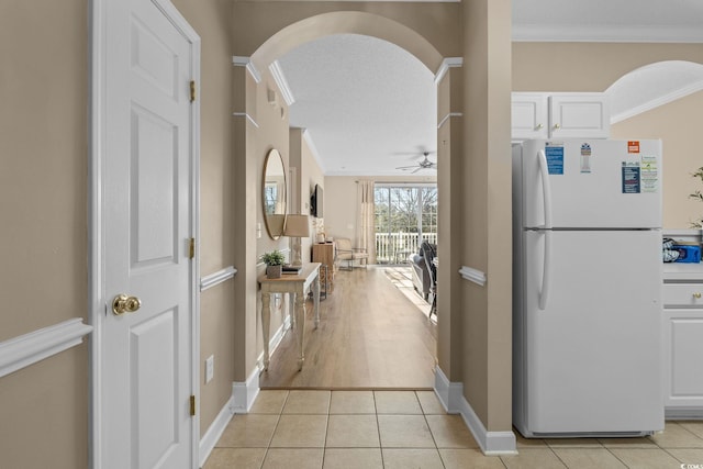 corridor featuring crown molding and light tile patterned floors