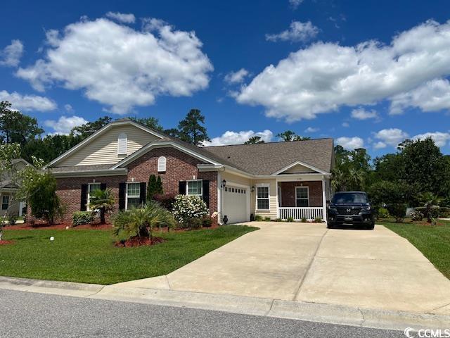 ranch-style house with a garage, covered porch, and a front yard