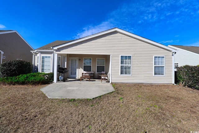 rear view of property with a yard and a patio