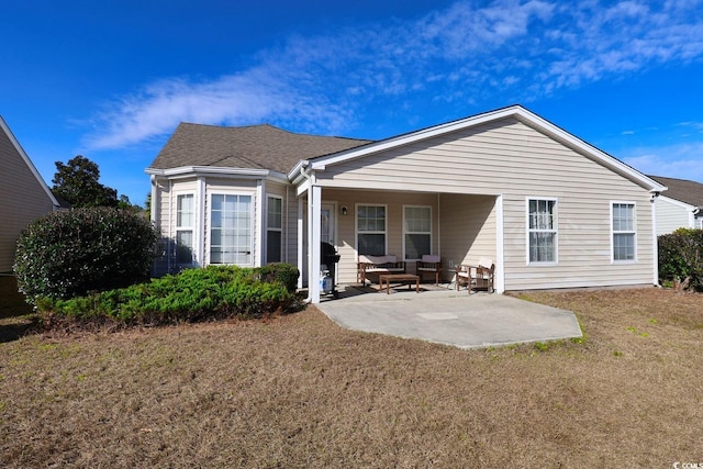 back of house featuring a lawn and a patio area