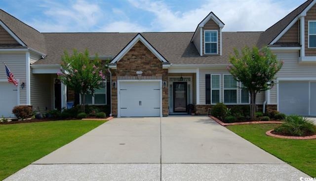 craftsman inspired home with a garage and a front lawn