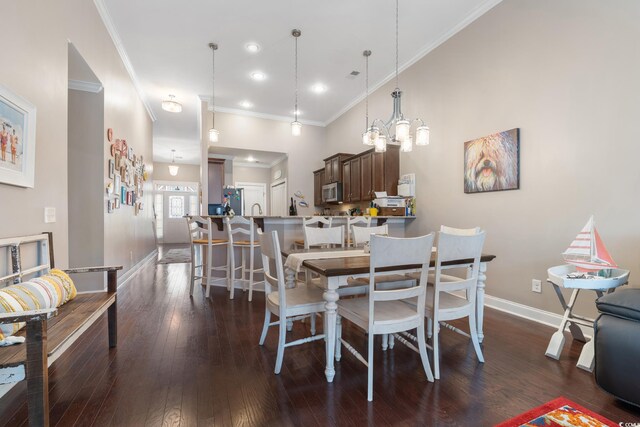 dining room with crown molding, dark hardwood / wood-style flooring, and an inviting chandelier