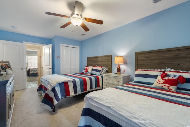 carpeted bedroom with ceiling fan and a closet