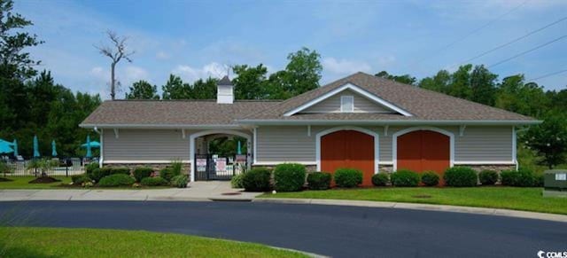 135 Parmelee Dr Unit D, Murrells Inlet, SC 29576 - view of front of home with stone siding, a chimney, and a gate