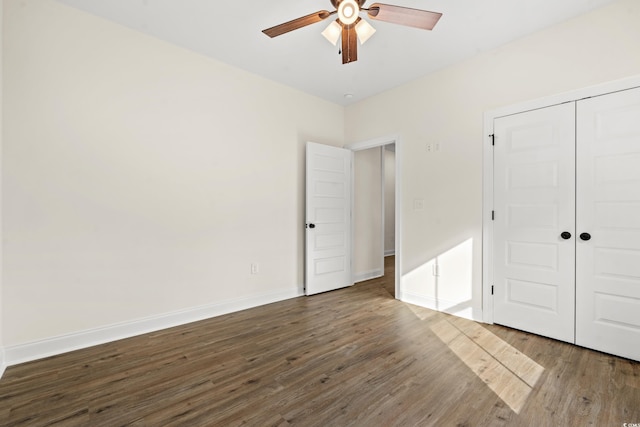 unfurnished bedroom with a closet, dark wood-type flooring, and ceiling fan