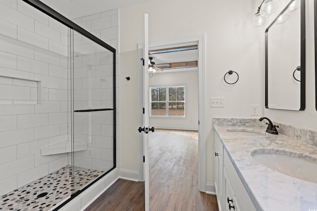 bathroom featuring ceiling fan, hardwood / wood-style floors, vanity, and a shower with door