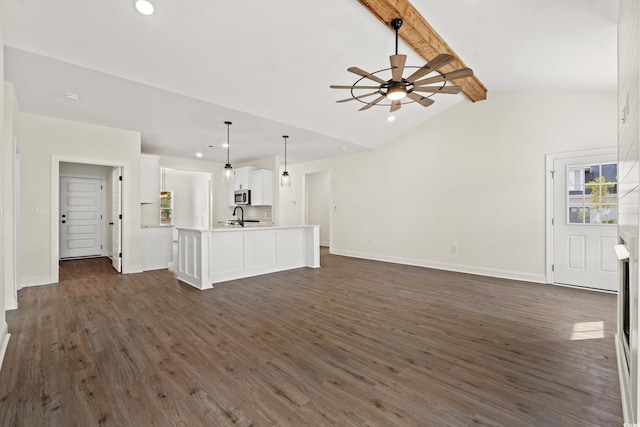 unfurnished living room with lofted ceiling with beams, ceiling fan, dark hardwood / wood-style flooring, and sink