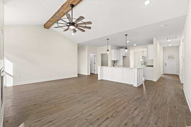 unfurnished living room with lofted ceiling with beams, ceiling fan, dark hardwood / wood-style flooring, and sink