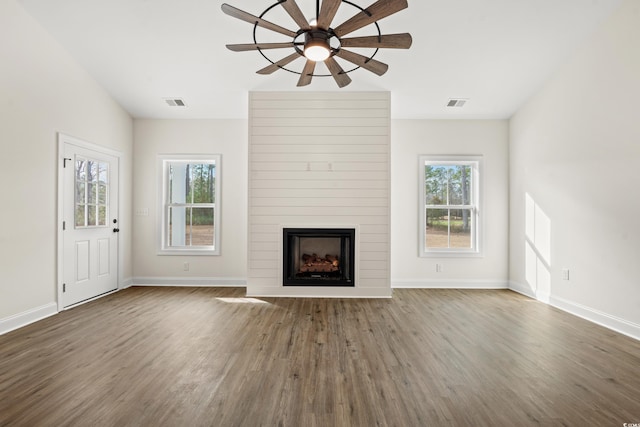 unfurnished living room featuring dark hardwood / wood-style floors, ceiling fan, and a fireplace