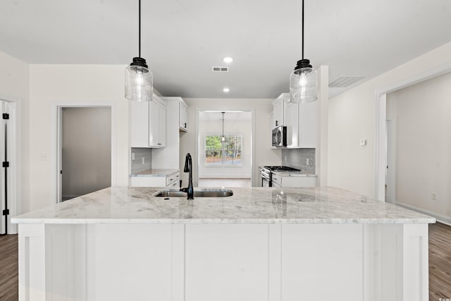 kitchen featuring pendant lighting, white cabinetry, sink, and stainless steel appliances