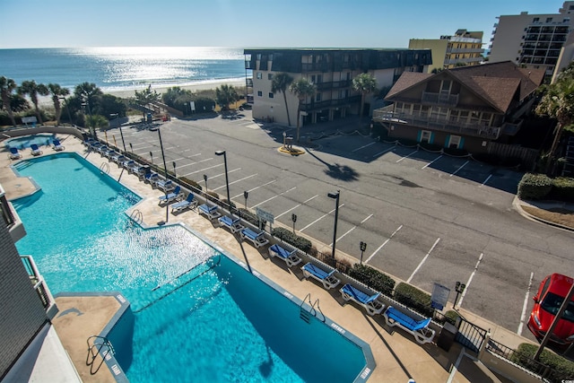 view of swimming pool with a water view and a patio