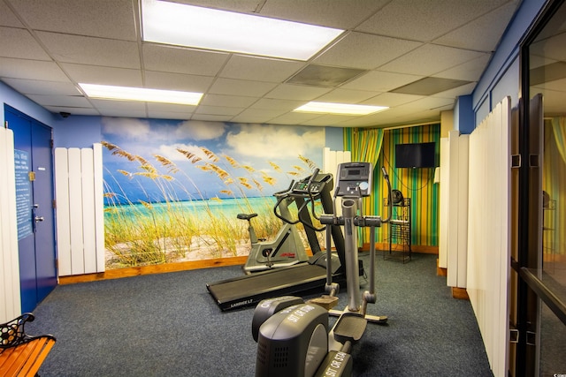 workout room with dark colored carpet and a drop ceiling