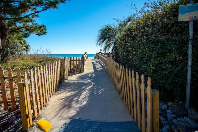 view of property's community featuring a water view and a beach view