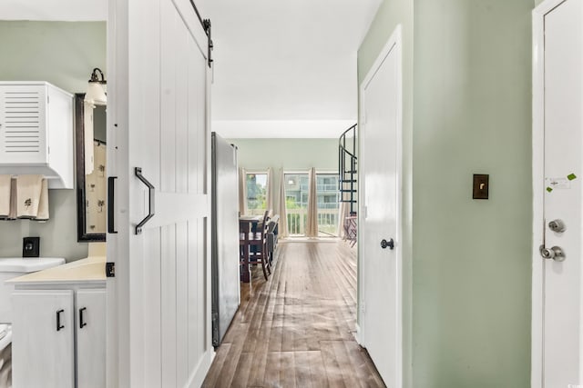 hall featuring hardwood / wood-style flooring and a barn door