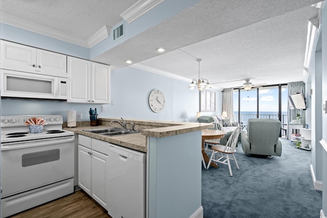 kitchen with a textured ceiling, kitchen peninsula, white cabinets, and white appliances