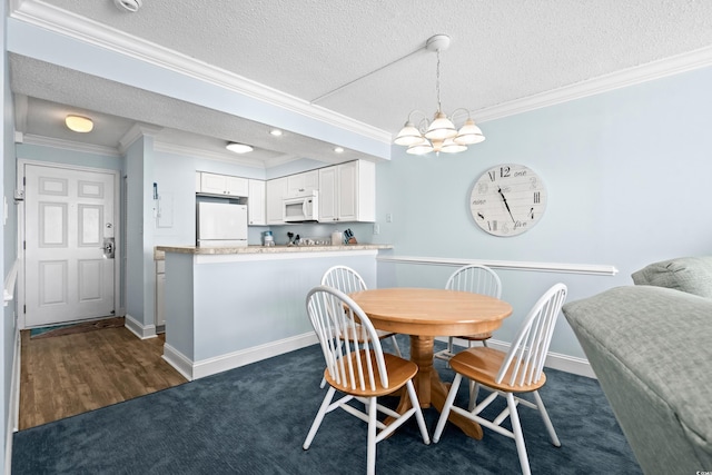 carpeted dining space with a textured ceiling, crown molding, and a notable chandelier