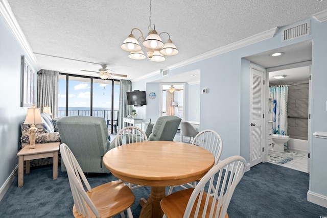 carpeted dining space with ceiling fan with notable chandelier, a textured ceiling, floor to ceiling windows, and ornamental molding