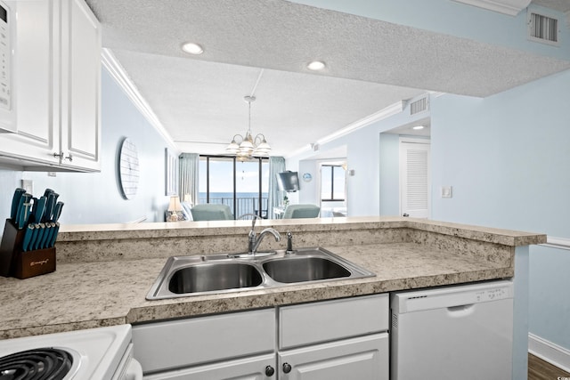 kitchen featuring white dishwasher, white cabinets, sink, and a textured ceiling